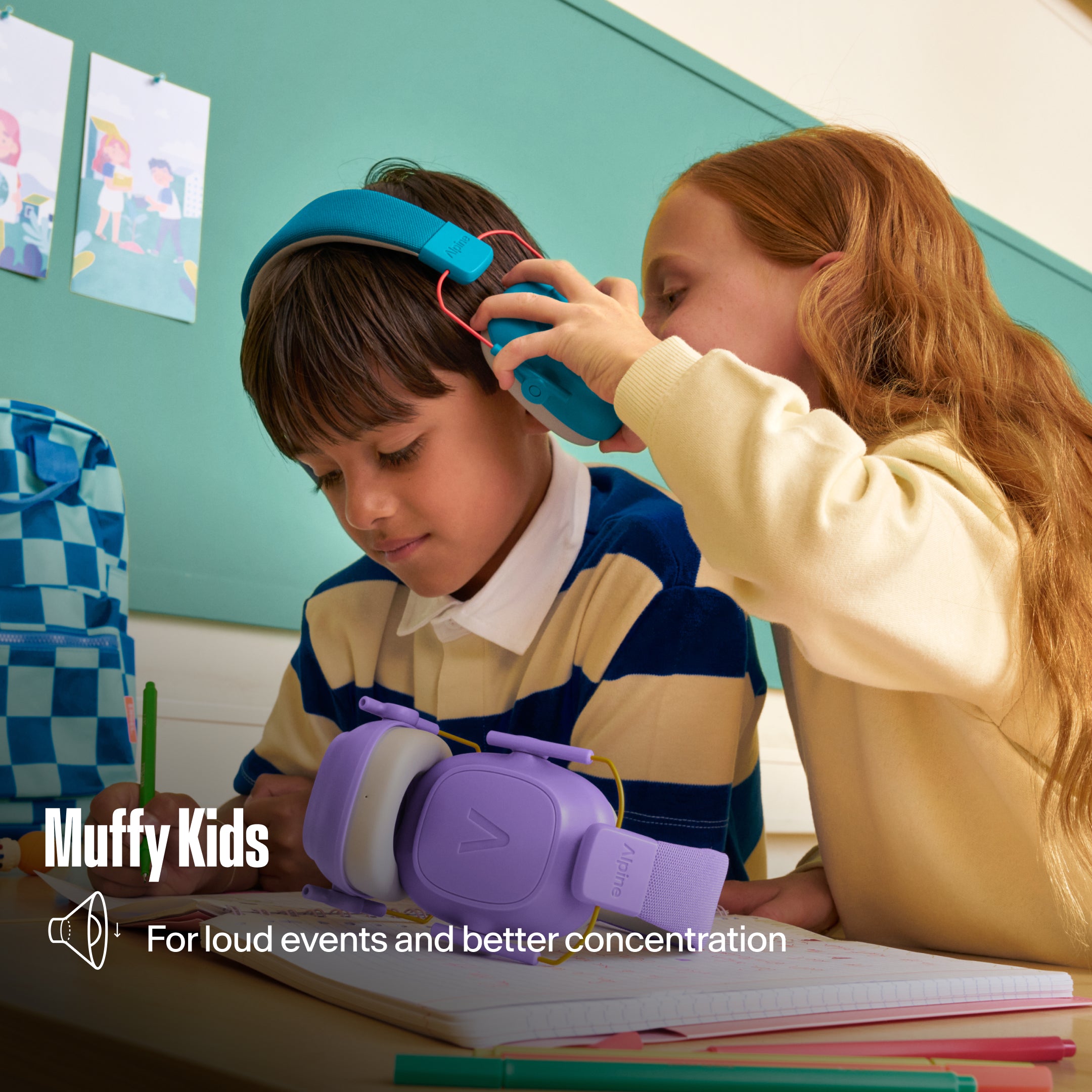 Alpine Muffy Kids earmuffs put on a boy by a girl at a school desk, with the text &