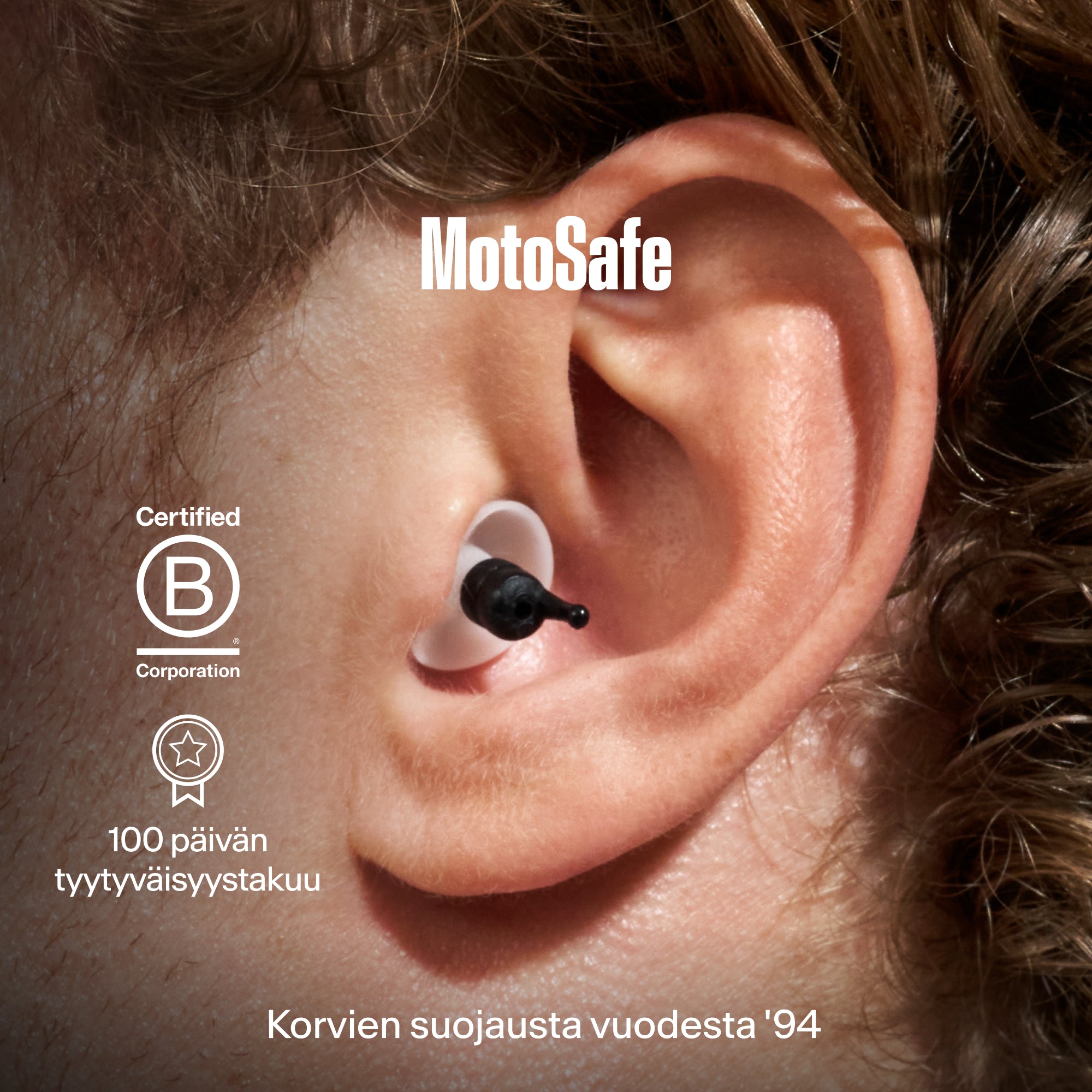 Lähikuva korvasta, jossa on Alpine MotoSafe Tour -korvatulppa, sekä Certified B Corporation, "100 päivän tyytyväisyystakuu" ja "Korvien suojausta vuodesta &