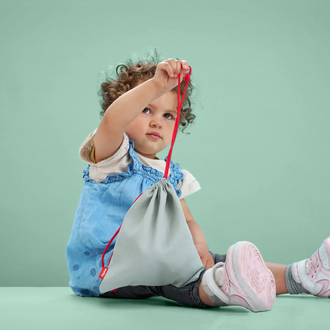 Toddler holding Alpine Muffy Baby storage bag 