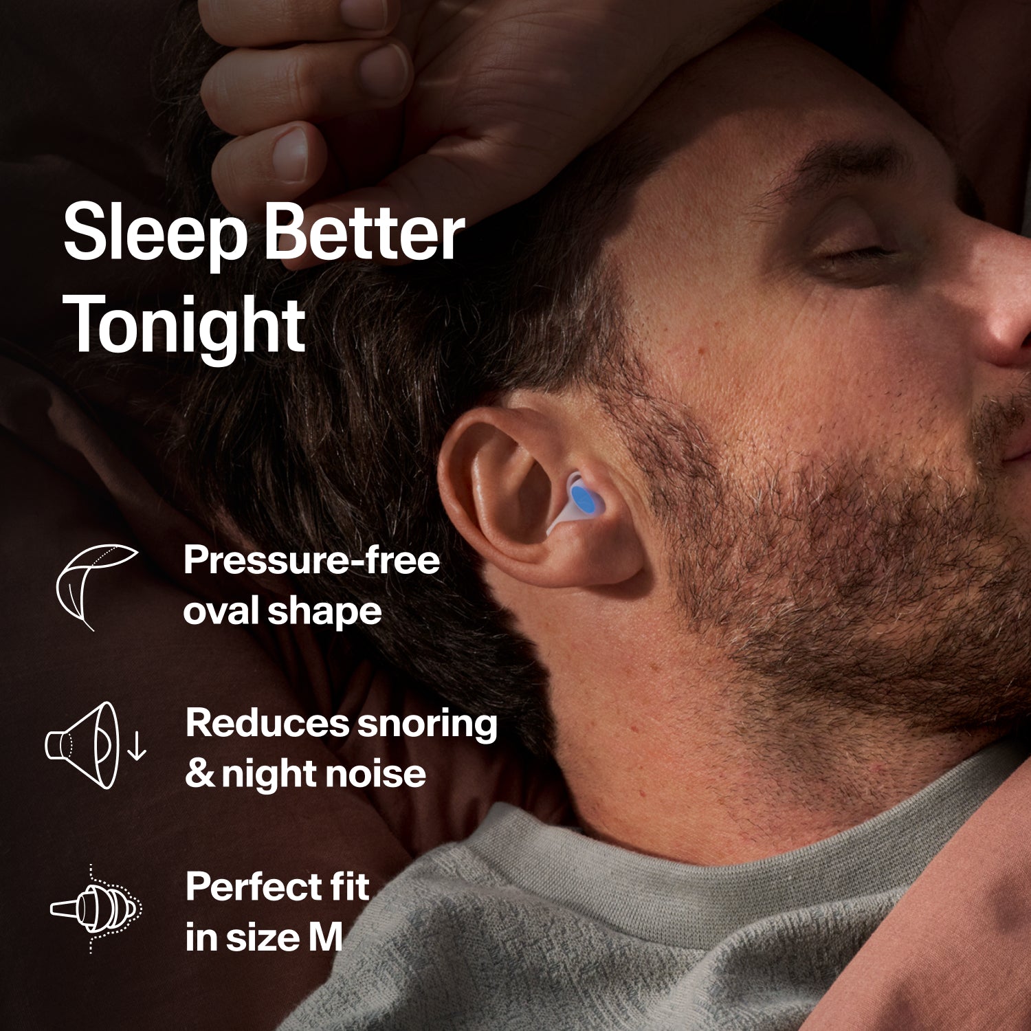 Man asleep on his side wearing an Alpine SleepDeep earplug, size M, to block snoring and night noises 