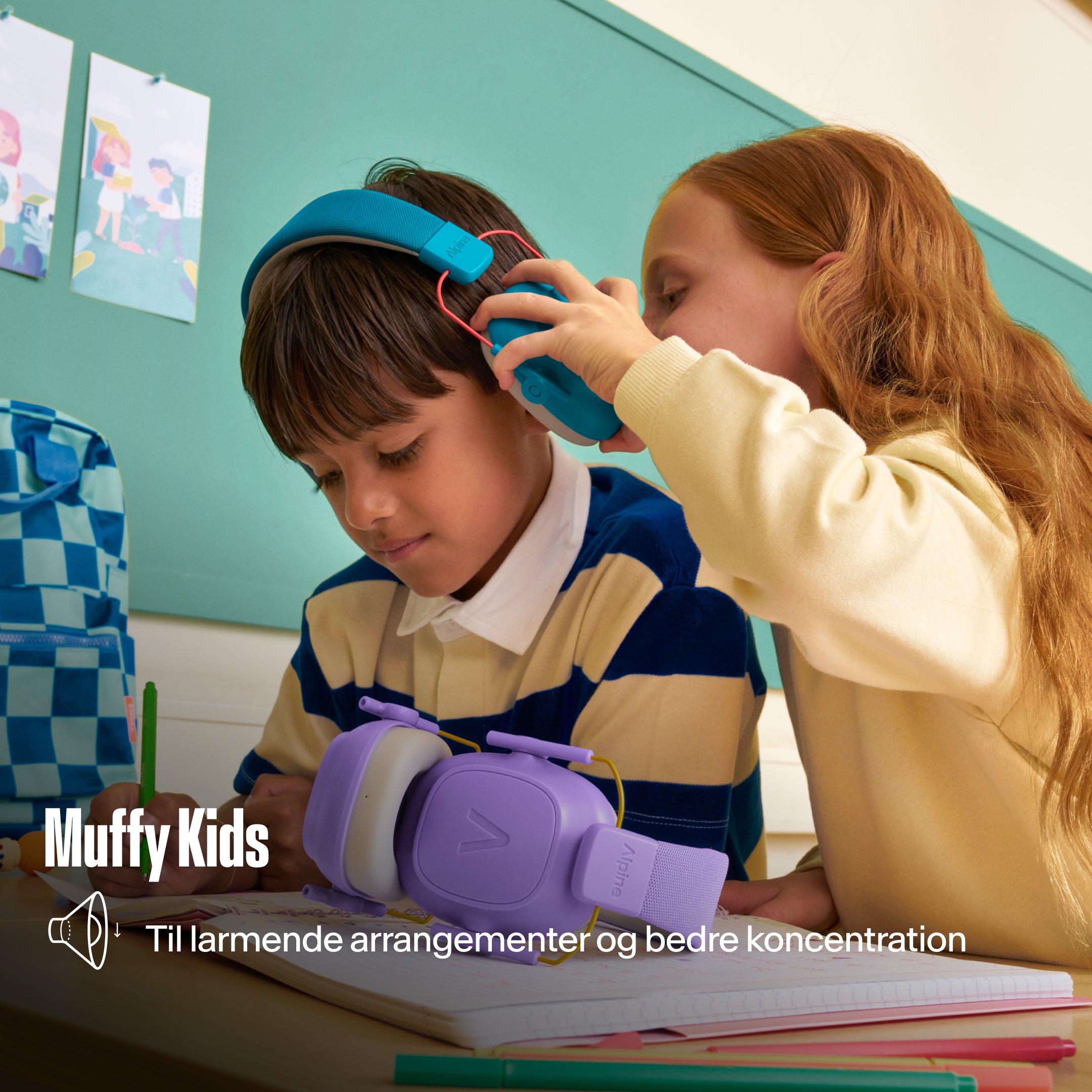 Alpine Muffy Kids høreværn, som en pige sætter på en dreng ved et skolebord, med teksten &