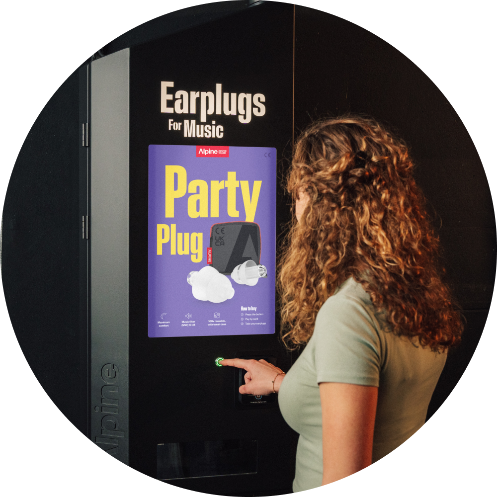 Vrouw bij alpine verkoopautomaat waar men partyplugs kan kopen