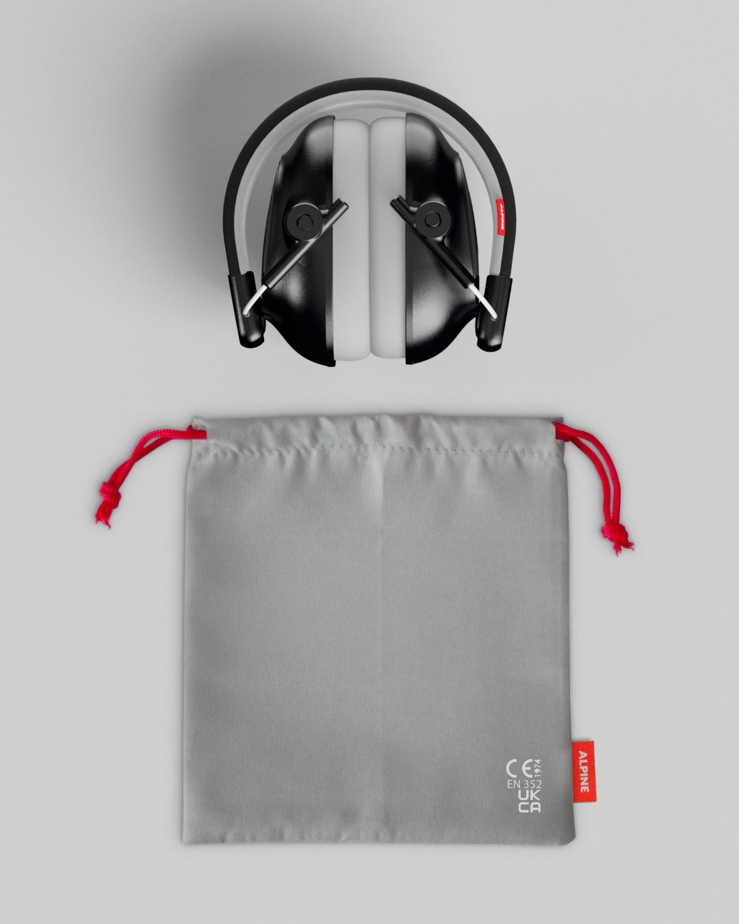 Alpine Muffy Baby ear defenders in black, folded, with grey carrying pouch 